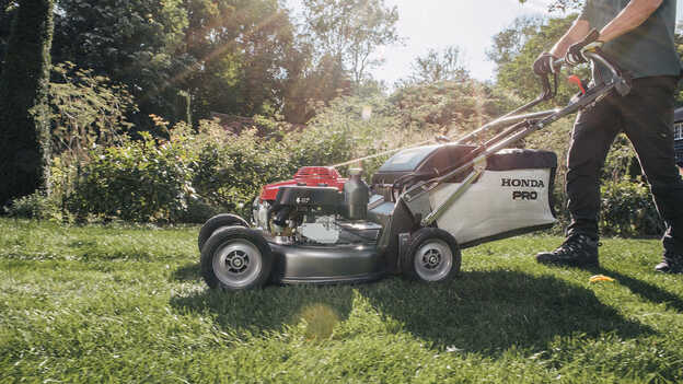 Seitenansicht eines Honda HRH, der in einem Garten verwendet wird. 
