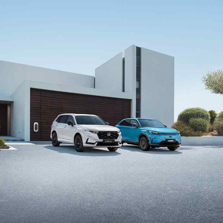 Eine Reihe von Honda-Hybridfahrzeugen, die vor einem Gebäude geparkt sind.