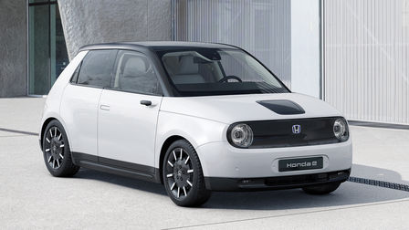 3/4-Frontansicht, Honda-e mit Gebäude im Hintergrund.
