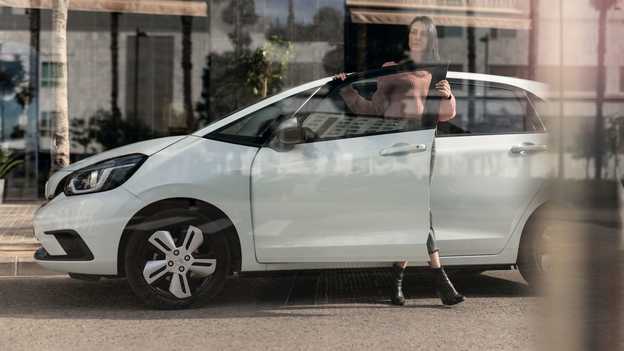 Honda Jazz, Seitenansicht, geparkt, Fahrerin öffnet die Tür