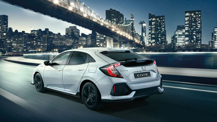 Honda Civic Dynamic in 3/4-Heckansicht bei der Fahrt durch die Stadt.
