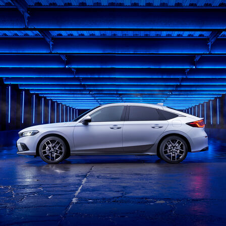 Seitenansicht eines in einer Seitenstraße geparkten Honda Civic e:HEV