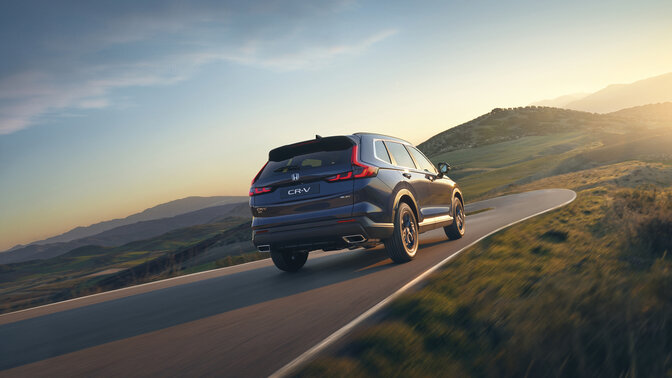 CR-V Hybrid SUV in Blau, Heckansicht im Gebirge.
