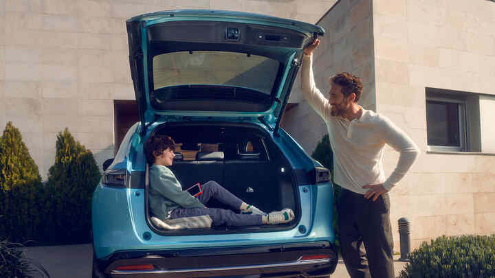 Vater, der mit einem Kind spricht, das im Kofferraum eines Honda e:Ny1 sitzt.