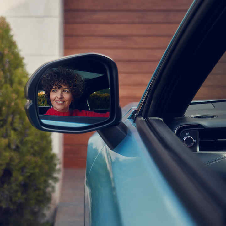 Spiegelbild einer Frau im Außenspiegel eines Honda e:Ny1.