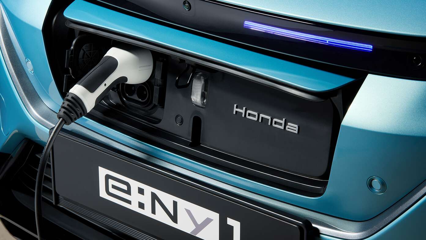Honda e:Ny1, Nahaufnahme des leicht zugänglichen Ladeanschlusses an der Fahrzeugfront.