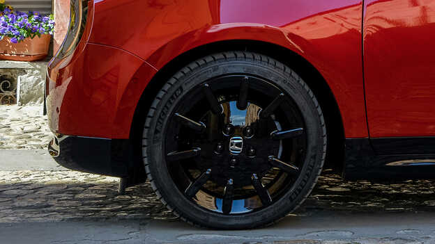 Nahaufnahme der schwarzen 16-Zoll-Räder des Honda e.