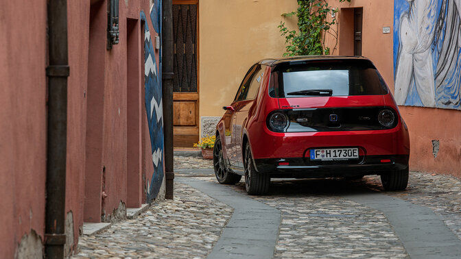 Honda e, 3/4-Heckansicht, in der Stadt. 