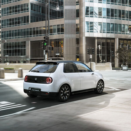 Honda e, 3/4-Heckansicht, in der Stadt.