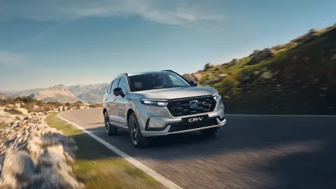 CR-V Plug-in-Hybrid in Weiß auf einer Gebirgsstraße.