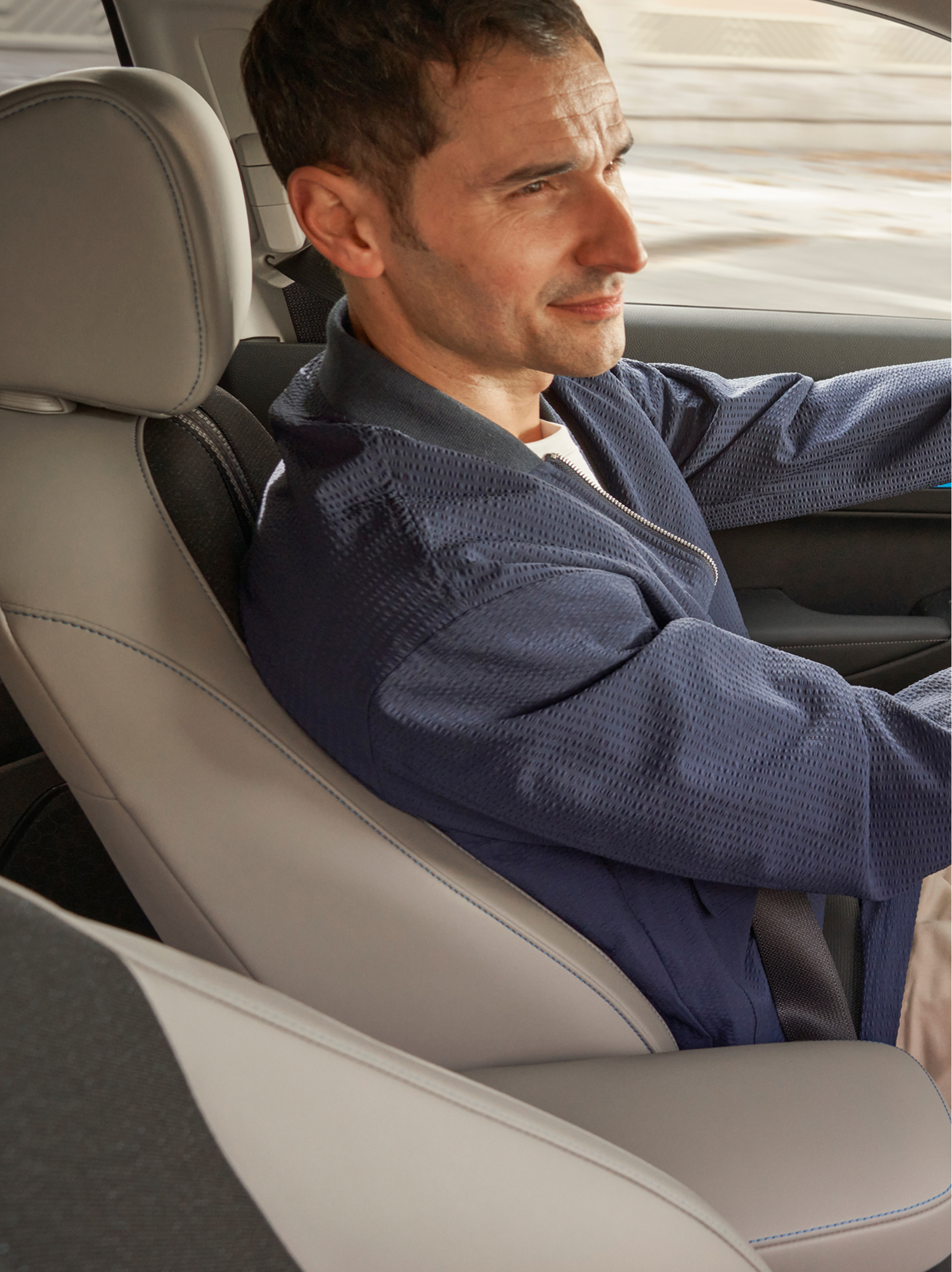 Ein Fahrer sitzt hinter dem Steuer eines Honda HR-V, von der Beifahrerseite aus gesehen, mit dem Innenraum-Armaturenbrett und einer Navigationskarte, die auf dem zentralen Bildschirm angezeigt wird.