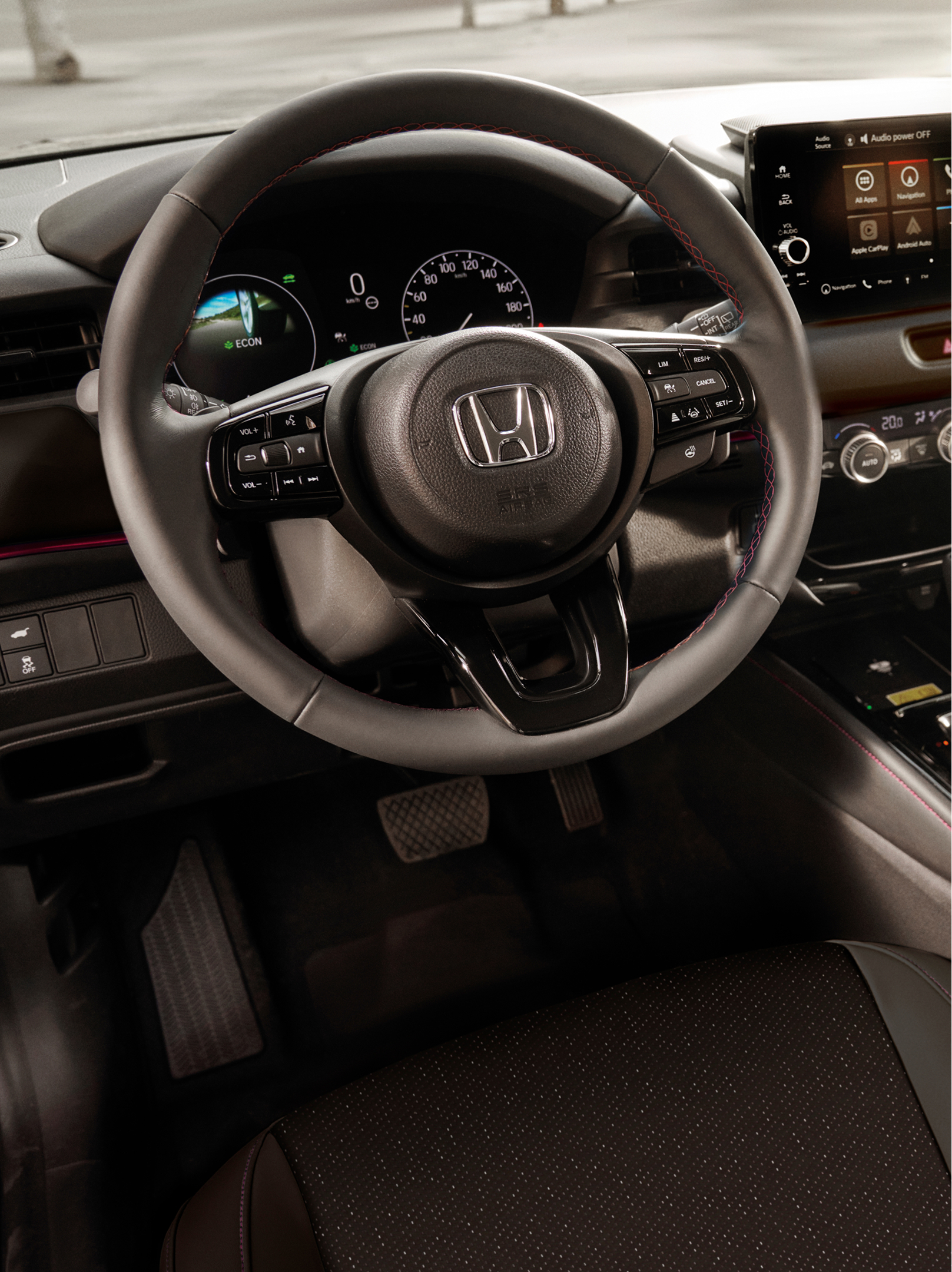 Innenansicht eines Honda HR-V mit Lenkrad, digitalem Kombiinstrument, zentralem Touchscreen und automatischem Schalthebel.