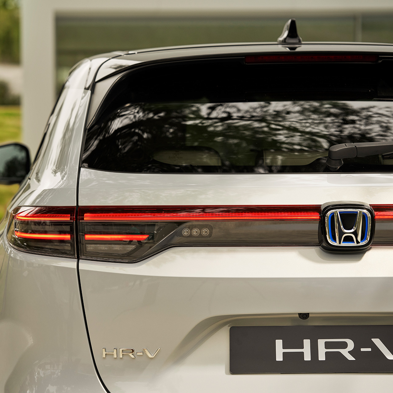 Ein Paar läuft neben einem HR-V, der vor einem Gebäude geparkt ist. 