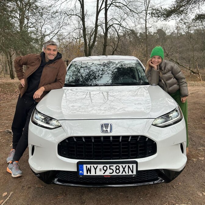 Zwei Influencer lehnen sich an die Honda ZR-V.