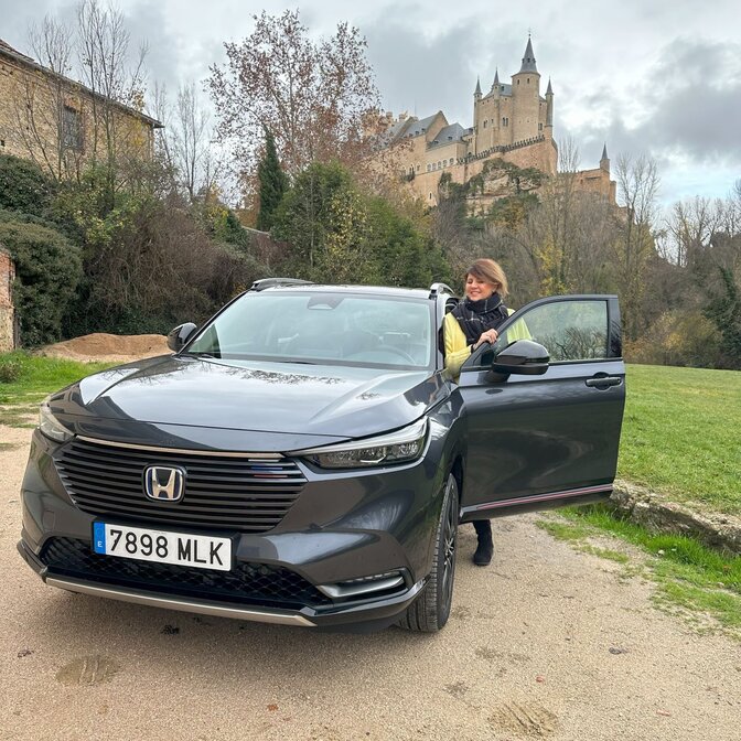 Ein Influencer steigt vor einem Schloss in einen Honda HR-V ein. 