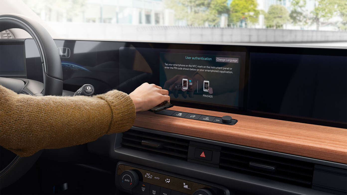Frau an der Rückseite eines Honda Jazz mit My Honda Plus App