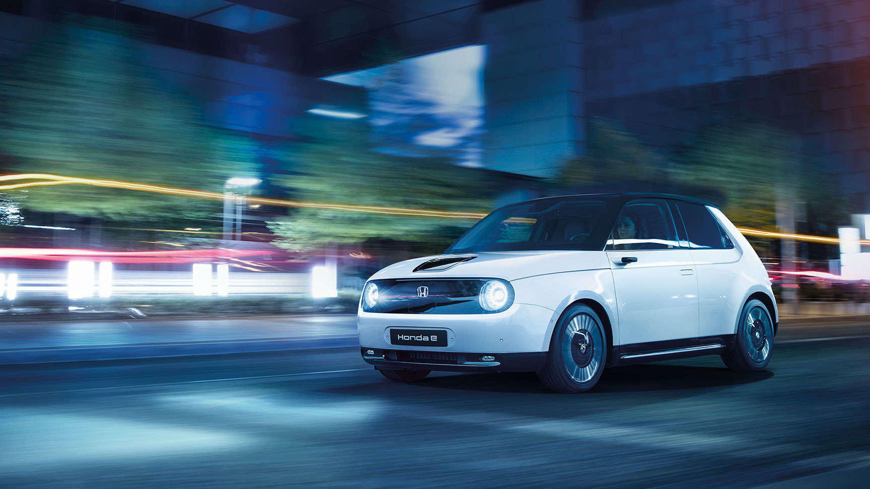 Weißer Honda e in der Stadt bei Nacht