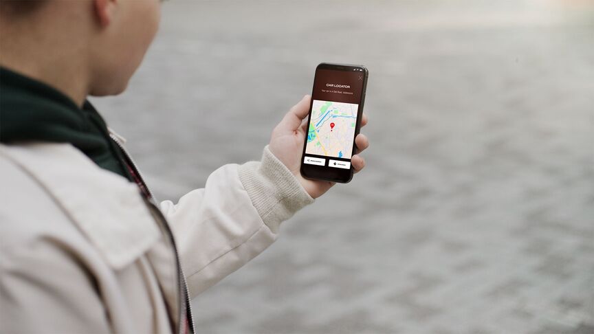 Nahaufnahme des digitalen Schlüssels in der My Honda Plus App vor urbanem Hintergrund