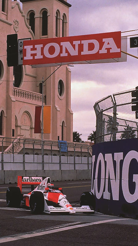 Dreivierteivorderansicht eines McLaren Honda Formel-1-Wagens beim Rennen auf der Strecke.