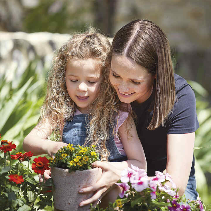 Mutter und Tochter beim Blumenpflanzen.