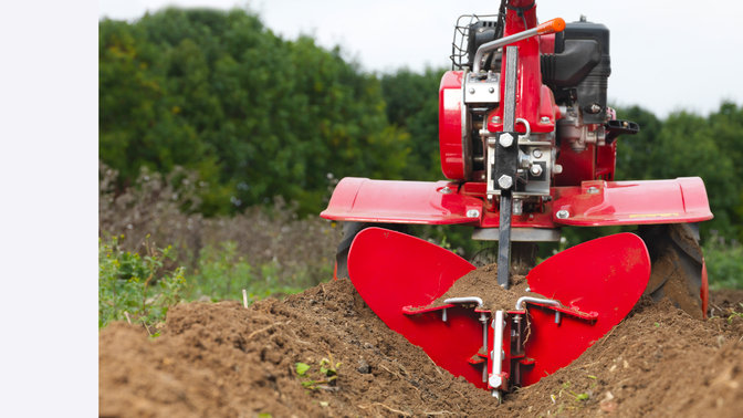 Nahaufnahme einer Motorhacke, Gartenumgebung.