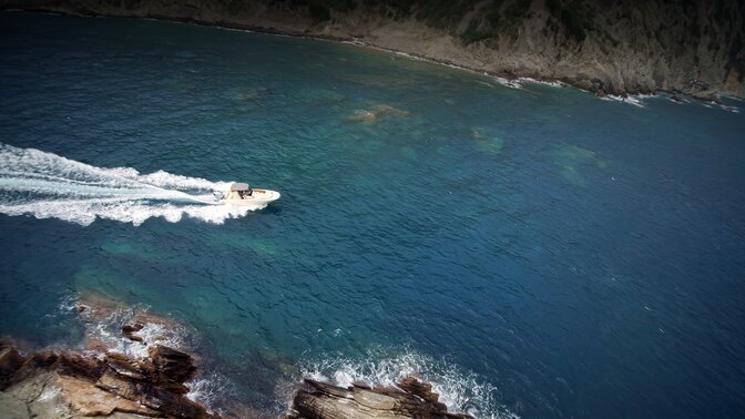 Luftaufnahme eines Bootes, das durch das Meer fährt.