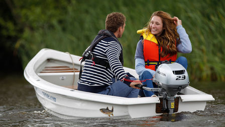 Ein lächelndes Paar in einem Boot auf einem See.