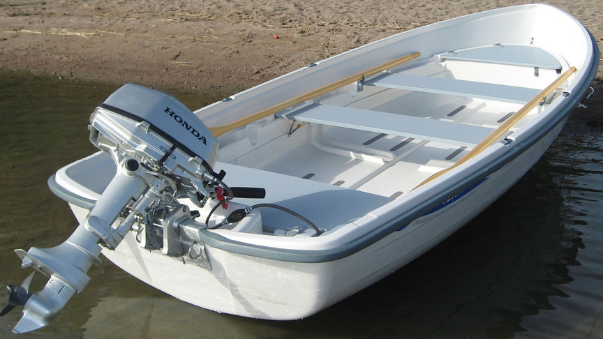 Boot auf Sand mit einem Außenborder von Honda.