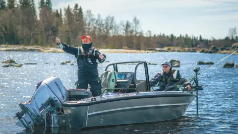 Zwei Männer beim Angeln auf einem Boot mit Honda BF60-Motor auf einem See. 