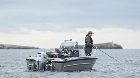 Zwei Männer beim Angeln auf einem Boot mit Honda BF60-Motor.