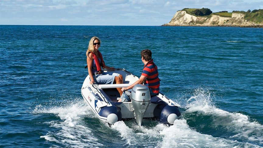 Mutter und Sohn fahren auf einem durch einen Honda Außenbordmotor BF8 angetriebenen Boot