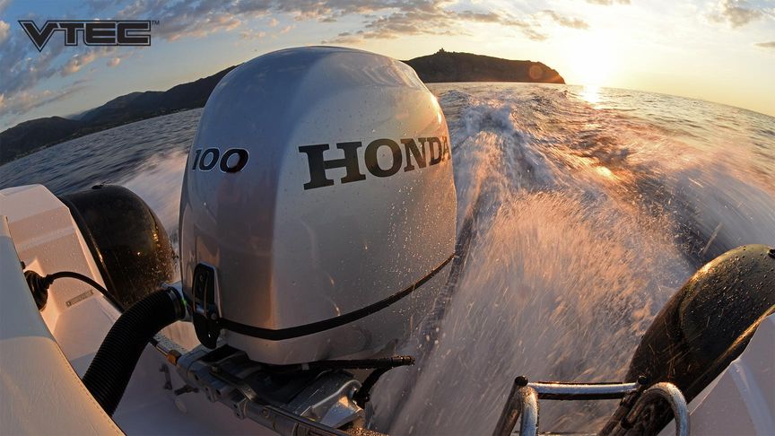 Nach hinten auf den Sonnenuntergang gerichteter Blick von einem sich bewegenden Schnellboot mit Sicht auf einen Honda Außenbordmotor BF100