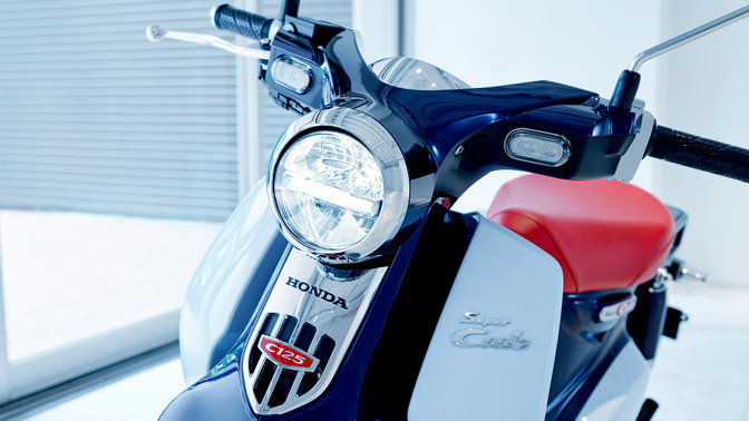 Honda Super Cub, abgestellt in moderner Umgebung.