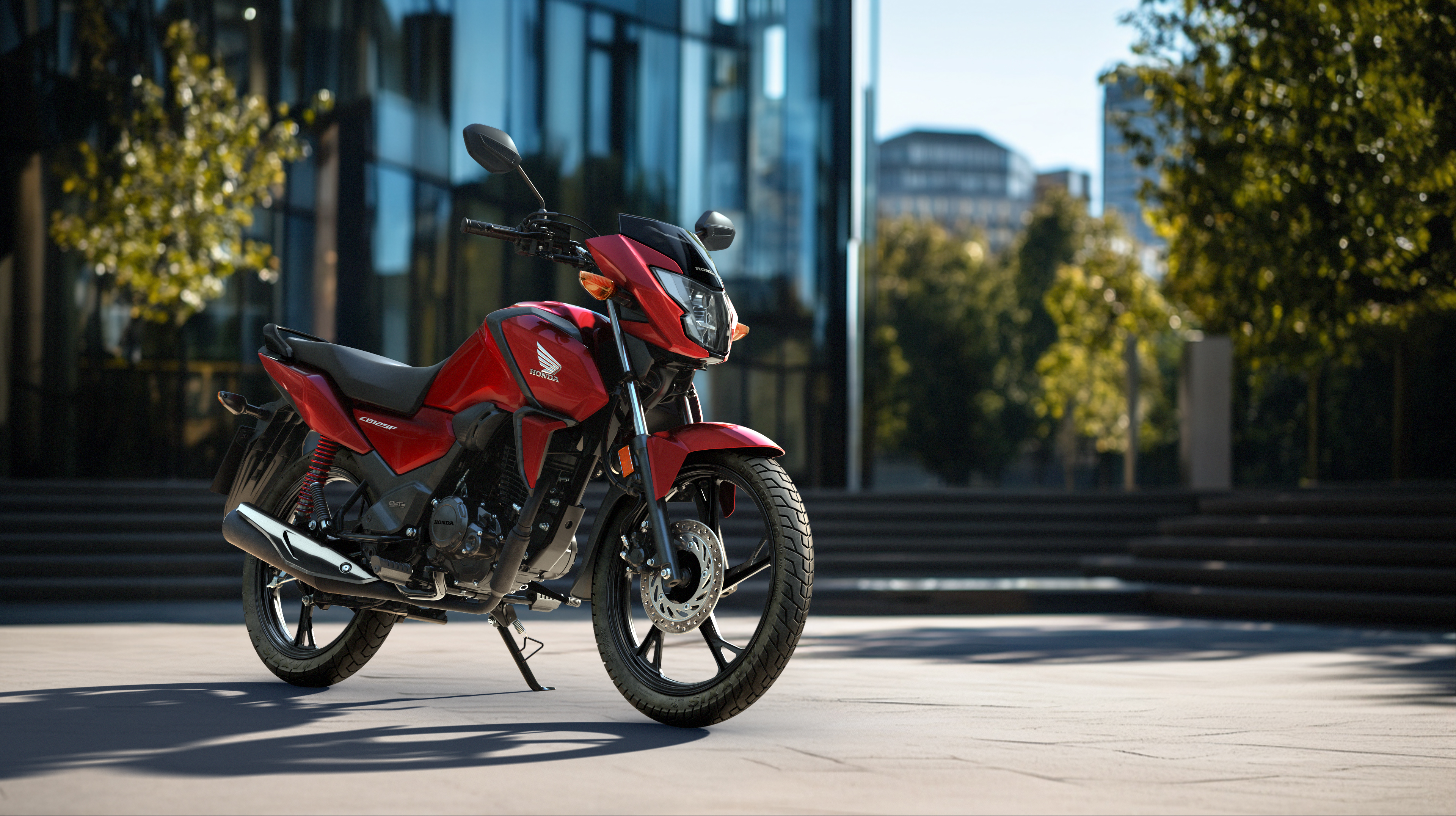 Front three-quarter, left facing CB125F red, on the road, urban location