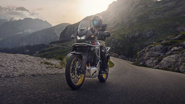 Dax 125 abgestellt, Dreiviertel-Heckansicht vor Meereshintergrund.