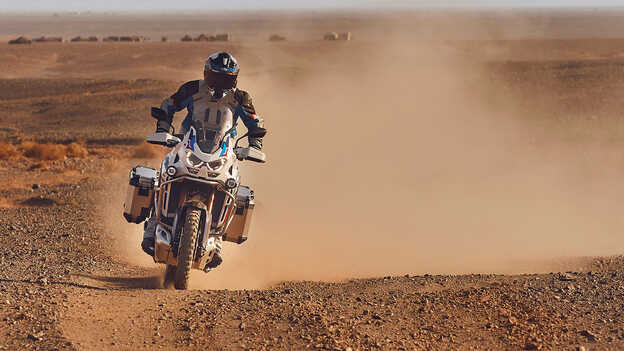 Fahrer auf Honda CRF1100 Africa Twin Adventure Sports in der Wüste, Vorderansicht.