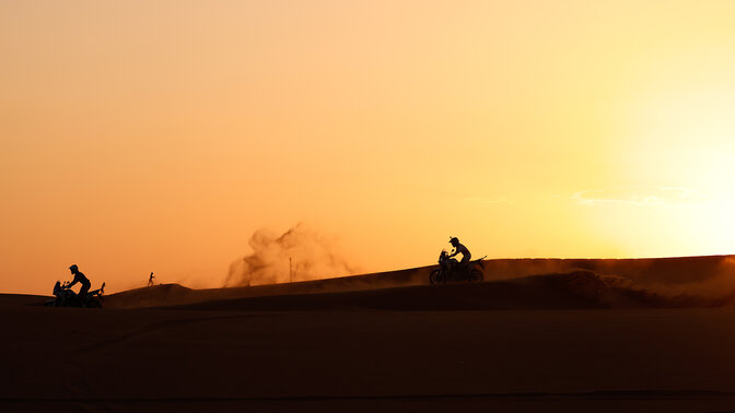 Honda Adventure Roads-Fahrer in der Wüste bei Sonnenuntergang.