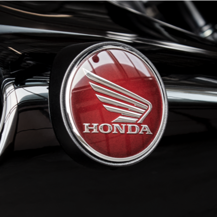 Frontansicht Honda Motorrad, auf dem ein Model sitzt. Außenaufnahme.
