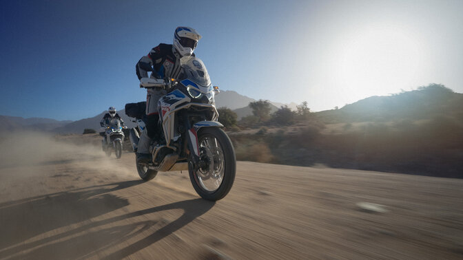 Zwei HAR-Fahrer auf einer Offroad-Piste, im Hintergrund ein Gebirge