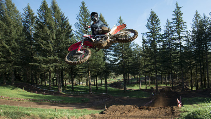 CRF450R im Sprung mit Fahrer im Gelände.