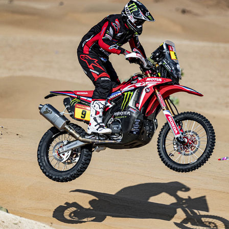 Honda Dakar-Fahrer auf einem Motorrad in der Wüste.