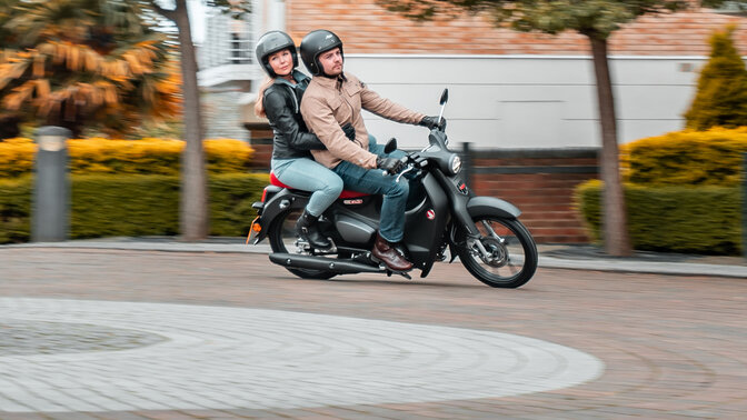 Honda Monkey auf Seitenständer auf der Straße mit Fahrer