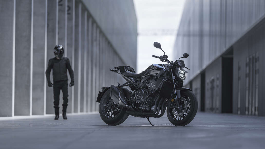 Honda CB1000R Black Edition – Mann zwischen Gebäuden neben dem Motorrad auf der Straße