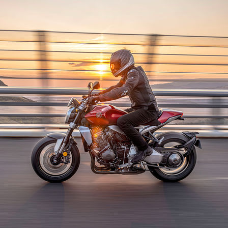 Honda CB1000R, linke Seite, mit Fahrer, auf der Straße bei Sonnenaufgang