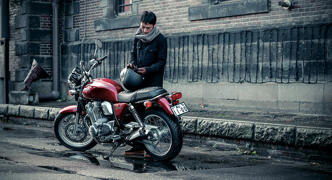 Dreiviertel-Heckansicht einer Honda CB1100EX mit Fahrer.