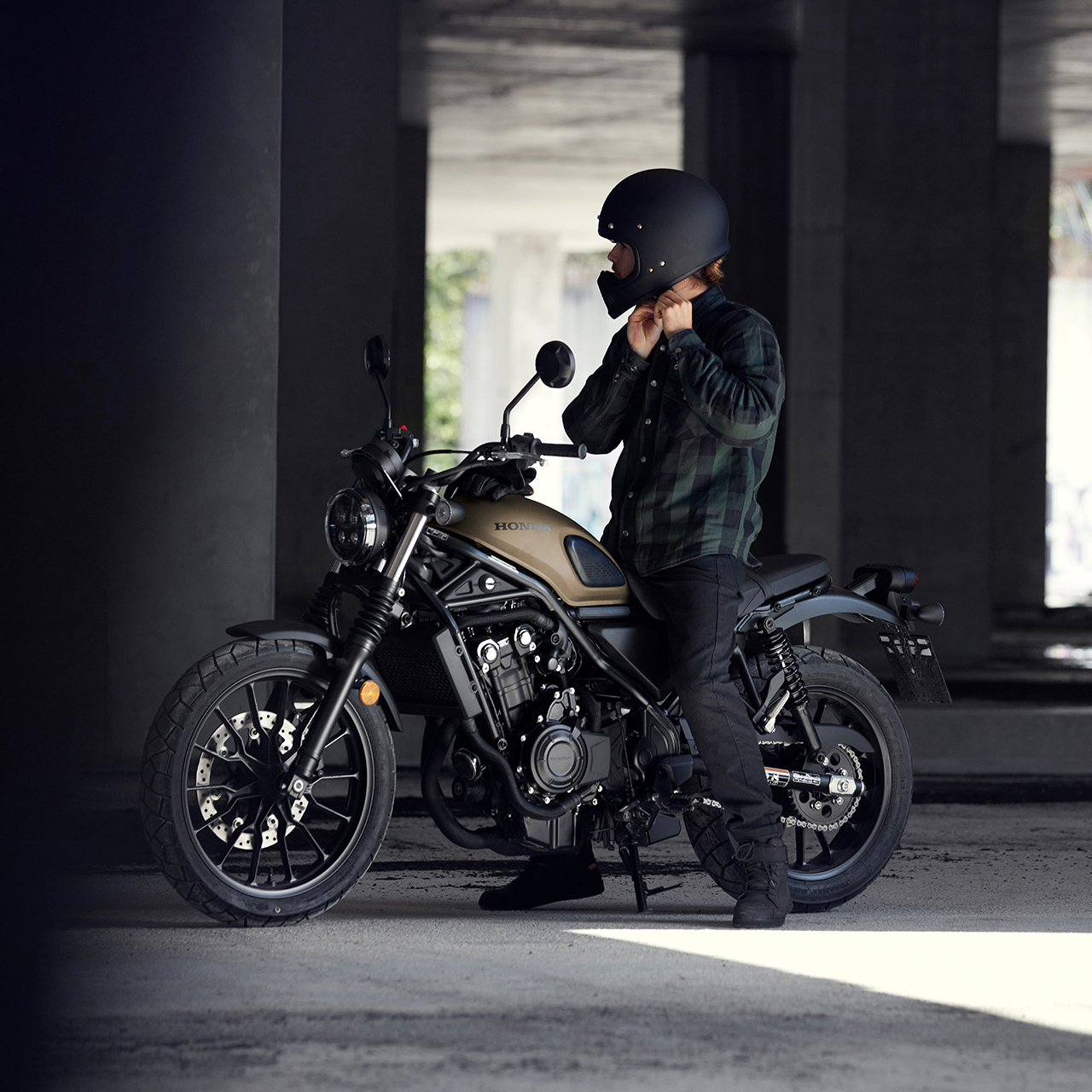 Fahrer auf Honda CL500 Motorrad, der seinen Helm vorbereitet.