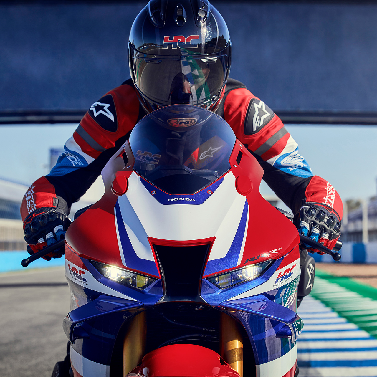 Nahaufnahme: Honda CBR1000RR-R Fireblade mit Fahrer auf der Rennstrecke, von vorne. 