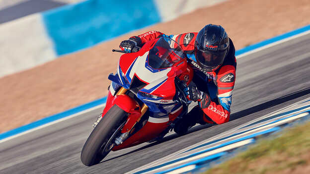 Honda CBR1000RR-R Fireblade with rider in a curve on the race track.