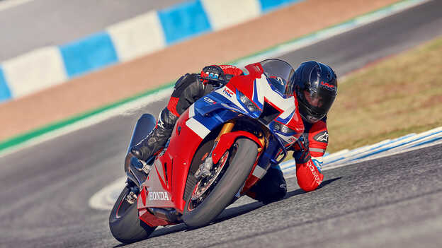 Honda CBR1000RR-R Fireblade with rider in motion on the race track accelerating out of a corner.