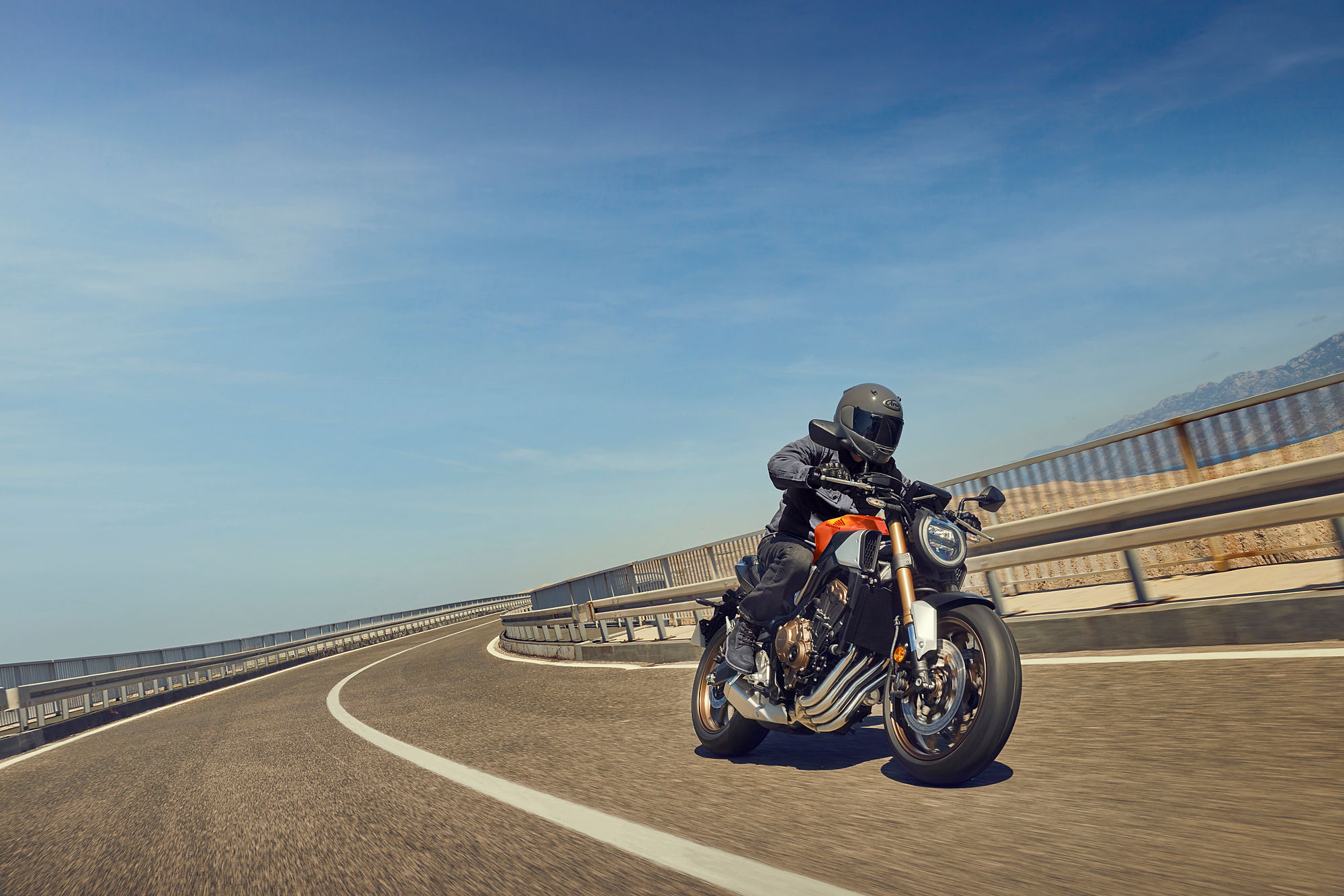 CB650R auf einer breiten asphaltierten Straße mit Leitplanke in einer Kurve
